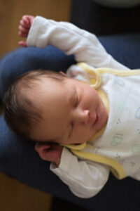 newborn baby sleeping on mom's lap