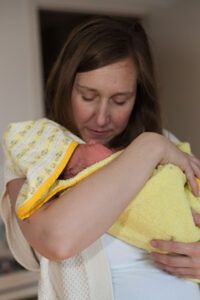 mom holding newborn baby after a bath