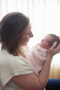 mom gazing lovingly at newborn baby