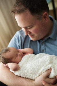 newborn baby in dad's arms, at home newborn photography session