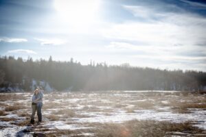engaged couple hugging in field