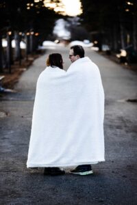 couple walking with blanket on wrapped around them