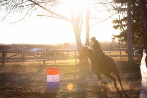 girl barrel racing at golden hour personalized Calgary grad session