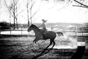 girl barrel racing at golden hour personalized Calgary grad session black and white
