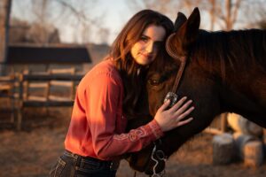 high school graduate and her horse at golden hour Calgary grad photo session