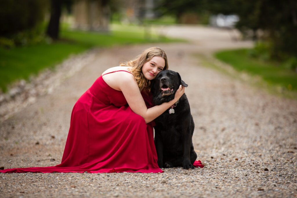 high school graduate in prom dress with her dog