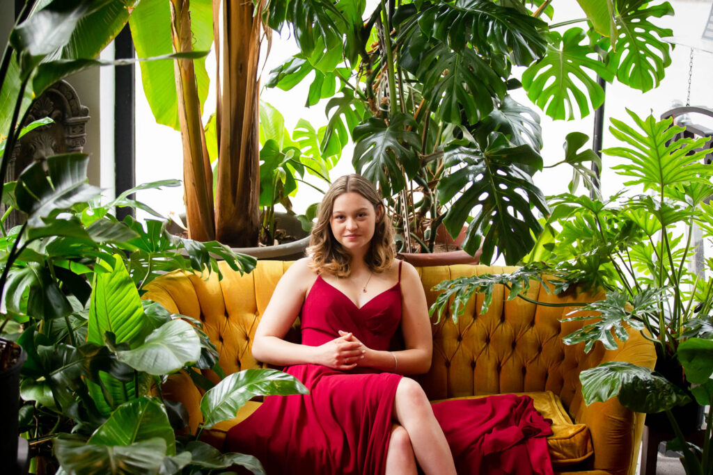 high school graduate in prom dress at a plant shop