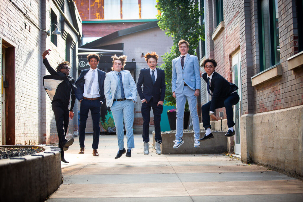 high school graduates jumping in suits