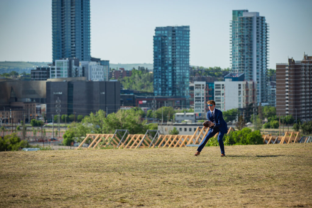 high school grad playing football in a suit Calgary Alberta