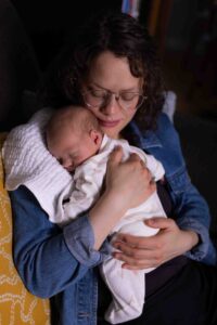 mom holding newborn baby Calgary newborn at home photography session with Baby I