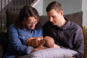 at home newborn photography session Calgary mom and dad holding newborn