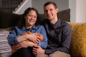 at home newborn photography session Calgary mom and dad holding newborn