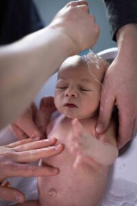 newborn baby getting first bath