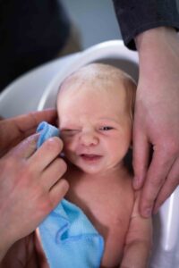 newborn baby getting first bath at home newborn photography session Calgary