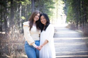 mother and graduate hugging in Griffith Woods Park Calgary