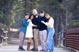family posing for picture on a bridge in Griffith woods park Calgary