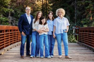 mixed race family posing on bridge in griffith woods calgary family photo session