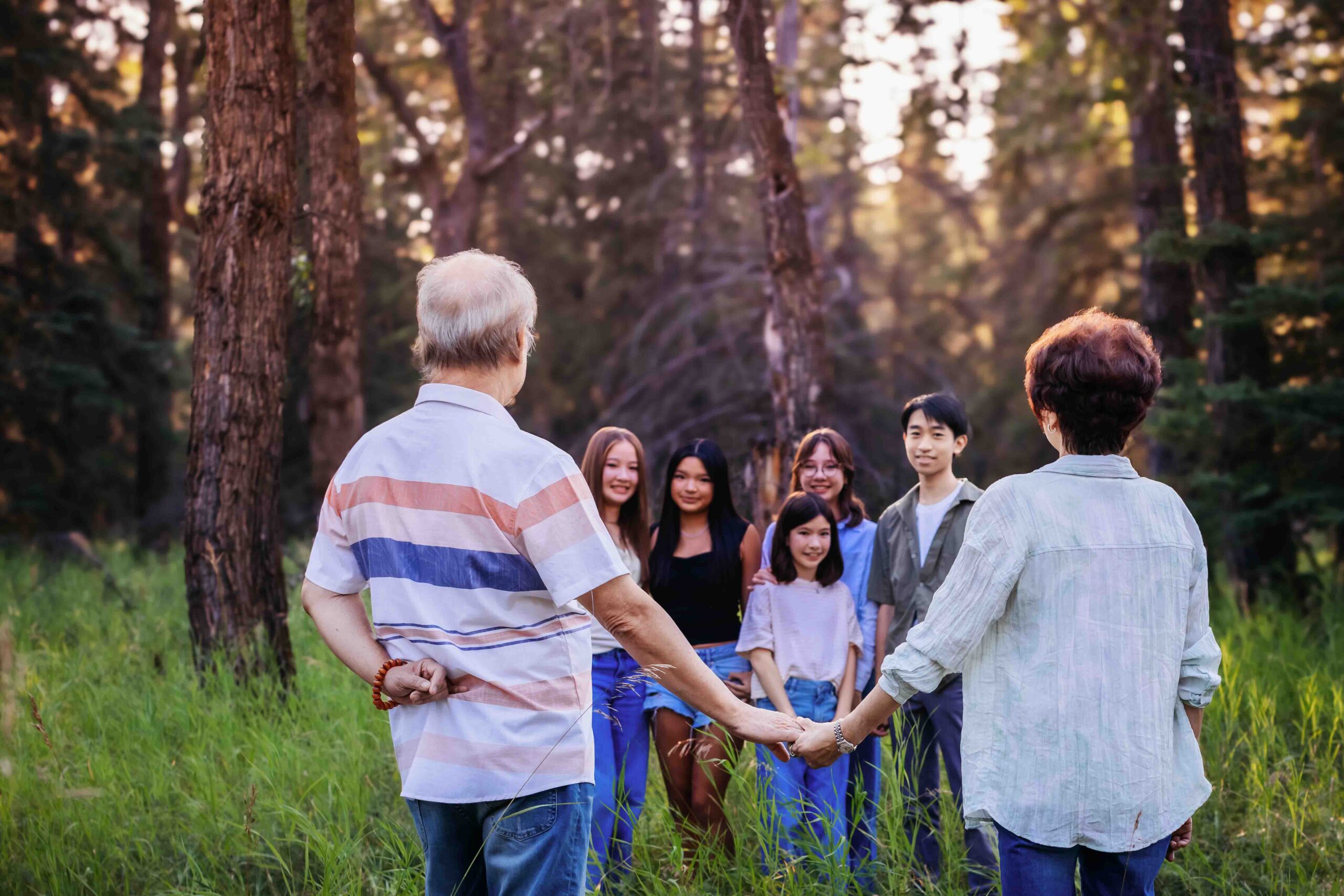 grandparents holding hands and looking at grandchildren calgary family photo session