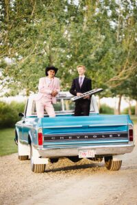two high school musicians standing in the back of a restored Chevrolet truck Calgary grad photoshoot