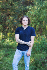young adult male posing for portrait photograph in Griffith Woods Calgary family photographer