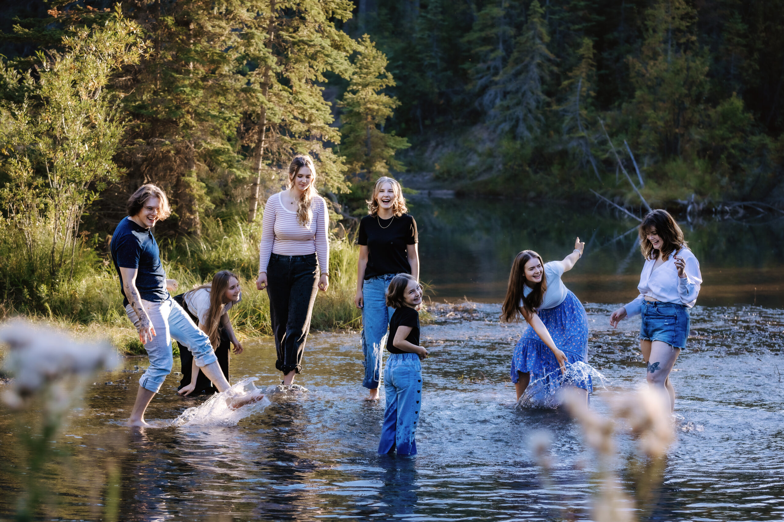 seven siblings splashing in water together in Griffith Woods Calgary family photographer