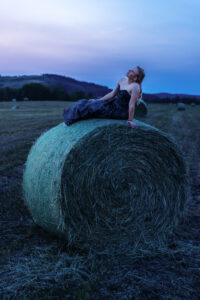 calgary high school grad sitting on hay bale in grad dress