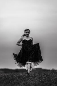 calgary high school grad running in field in grad dress