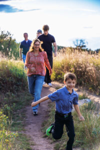 8 year old leading his family down a path at fish creek park calgary alberta