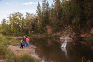 family of five throwing rocks into fish creek in calgary alberta