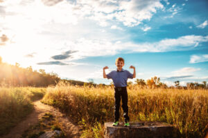 8 year old doing superman pose in fish creek park calgary alberta