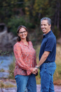 husband and wife posing for photos at fish creek park calgary alberta