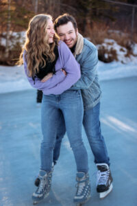 He sneaks up from behind and playfully hugs her as they skate on the frozen pond. She laughs, wearing her purple sweater, while he grins in his sherpa-lined jean jacket. The candid moment captures their joy and connection.