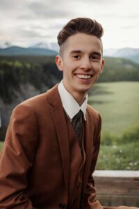Aiden smiling confidently in outdoor graduation photoshoot