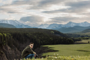 Aiden posing with a camera in nature, showcasing his passion for landscape photography