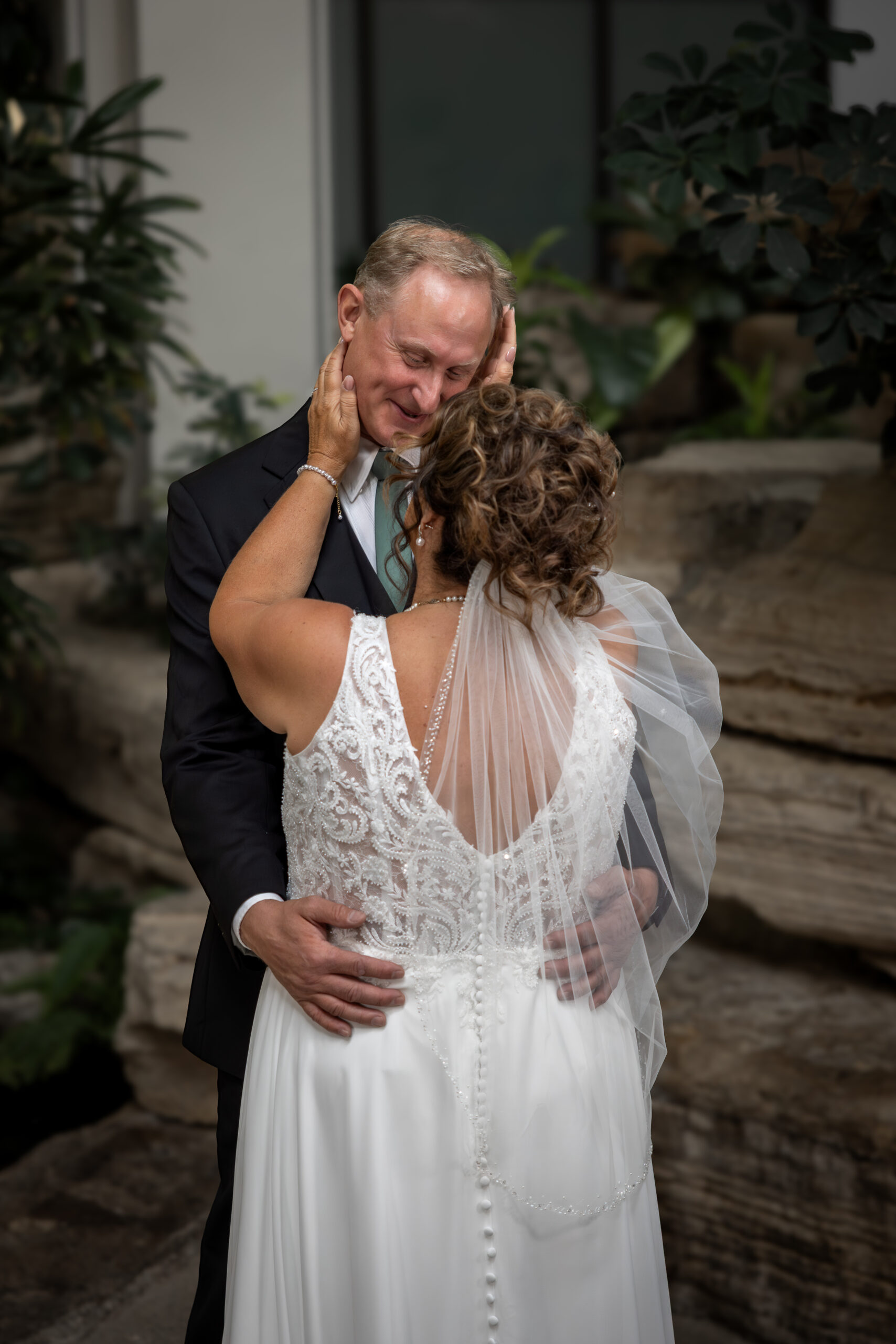 Calgary bride and groom sharing tender first look moment indoors on rainy wedding day