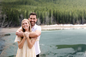 Couple hugging after surprise proposal in the Alberta mountains