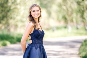 High school graduate Shayla wearing a navy blue graduation dress during a same-day graduation photo session.