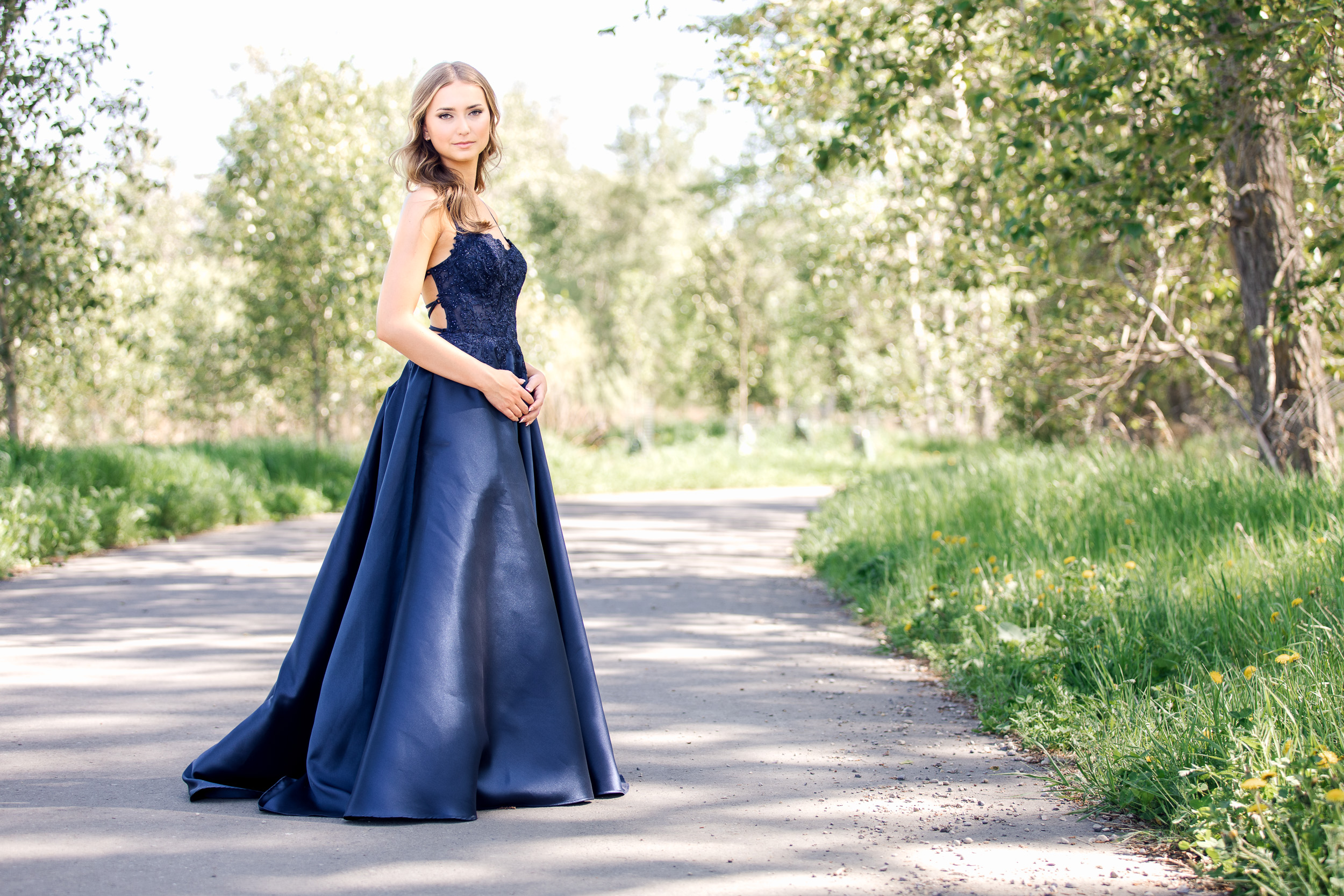 Graduate smiling during a same-day graduation photo session in a navy blue graduation dress.